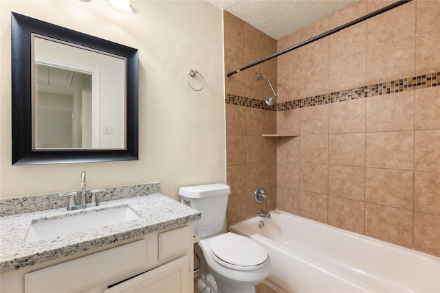 full bathroom with tiled shower / bath combo, toilet, a textured ceiling, and vanity