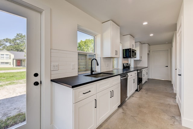 kitchen with backsplash, sink, white cabinets, and stainless steel appliances