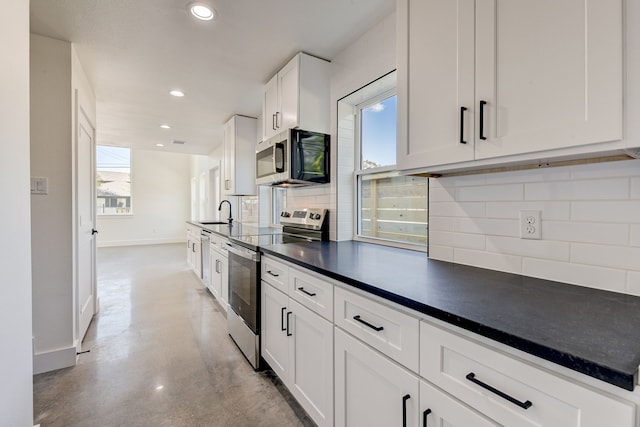 kitchen with white cabinets, a wealth of natural light, appliances with stainless steel finishes, and tasteful backsplash