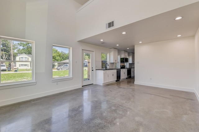 unfurnished living room with plenty of natural light and sink