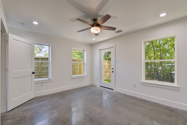 empty room with concrete floors and ceiling fan