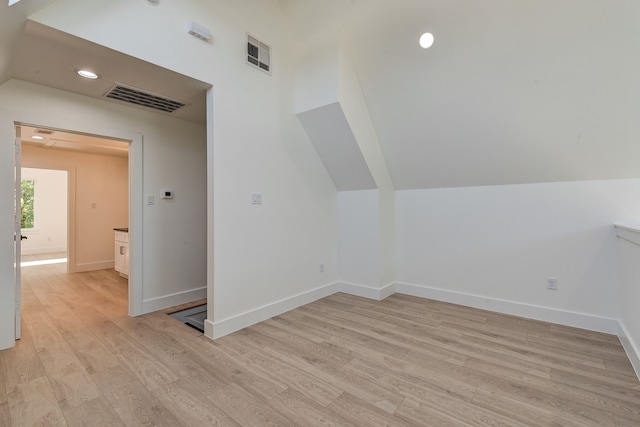 bonus room featuring lofted ceiling and light wood-type flooring