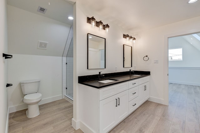 bathroom with vanity, a shower, hardwood / wood-style flooring, toilet, and lofted ceiling