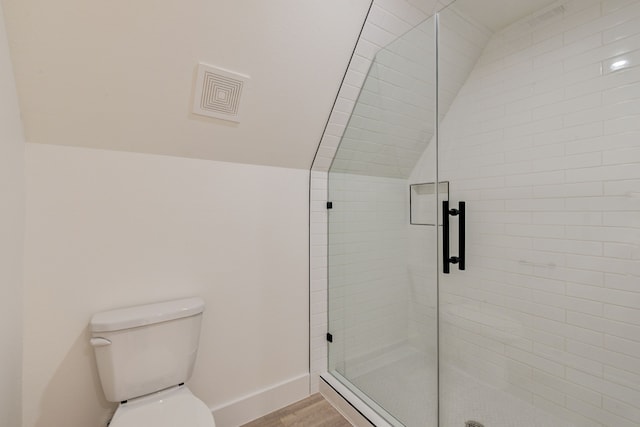 bathroom with toilet, a shower with door, lofted ceiling, and hardwood / wood-style flooring