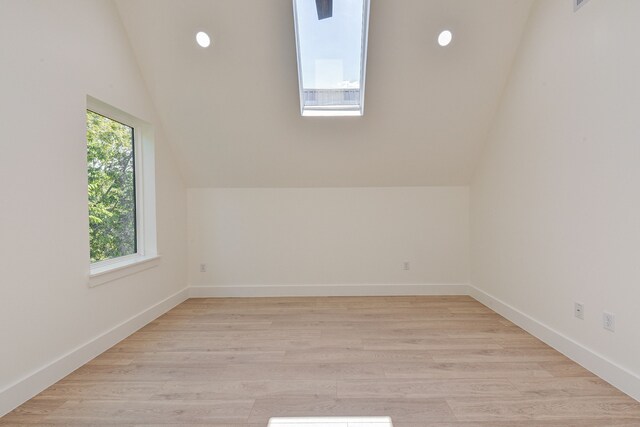 bonus room with light wood-type flooring and vaulted ceiling