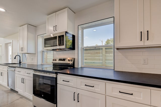 kitchen featuring decorative backsplash, appliances with stainless steel finishes, white cabinetry, and sink