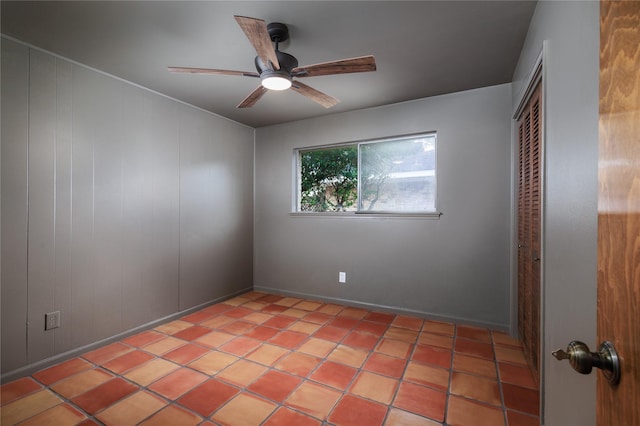 tiled spare room with ceiling fan