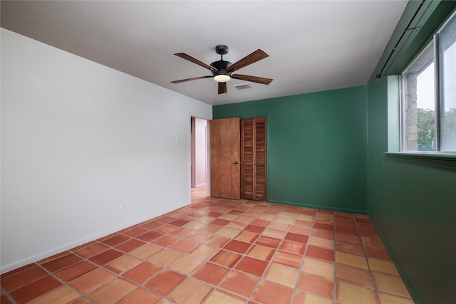 tiled spare room featuring ceiling fan