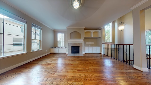 unfurnished living room with crown molding, a fireplace, and wood-type flooring