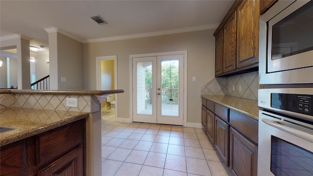 kitchen featuring backsplash, french doors, stainless steel appliances, and ornamental molding