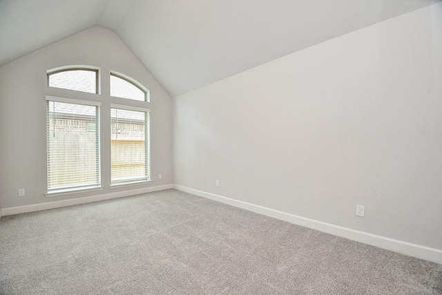 carpeted empty room featuring lofted ceiling