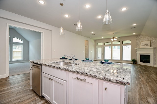 kitchen featuring plenty of natural light, white cabinetry, dishwasher, and vaulted ceiling