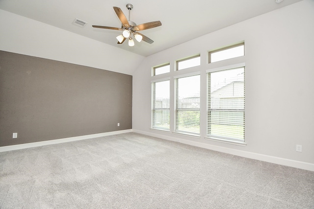 spare room with light colored carpet, vaulted ceiling, and ceiling fan