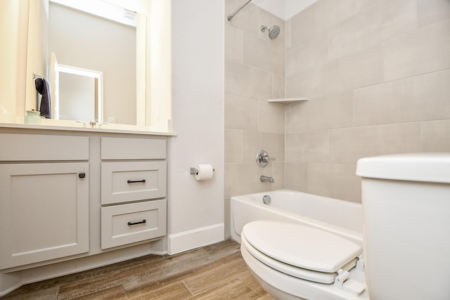 full bathroom with toilet, hardwood / wood-style floors, vanity, and tiled shower / bath