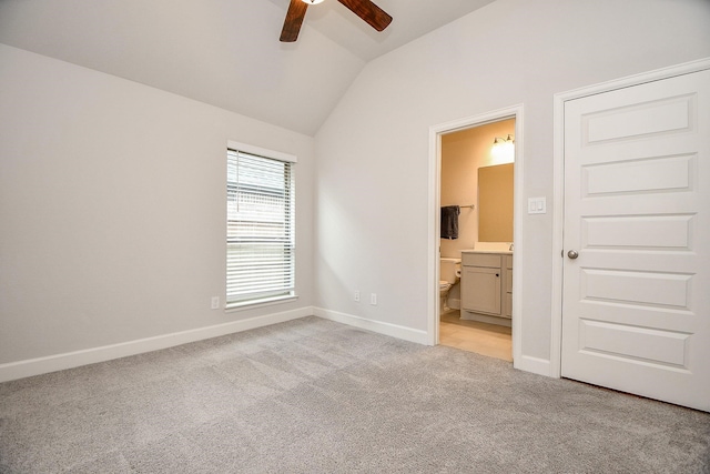 unfurnished bedroom with light carpet, vaulted ceiling, ensuite bath, and ceiling fan