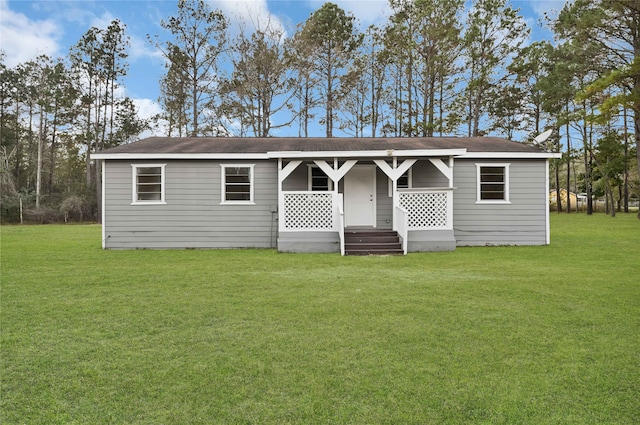 back of property with a lawn and covered porch