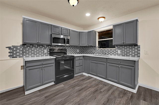 kitchen featuring gray cabinetry, dark wood-type flooring, sink, black electric range, and decorative backsplash