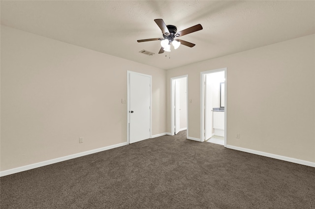 unfurnished room with dark colored carpet and ceiling fan