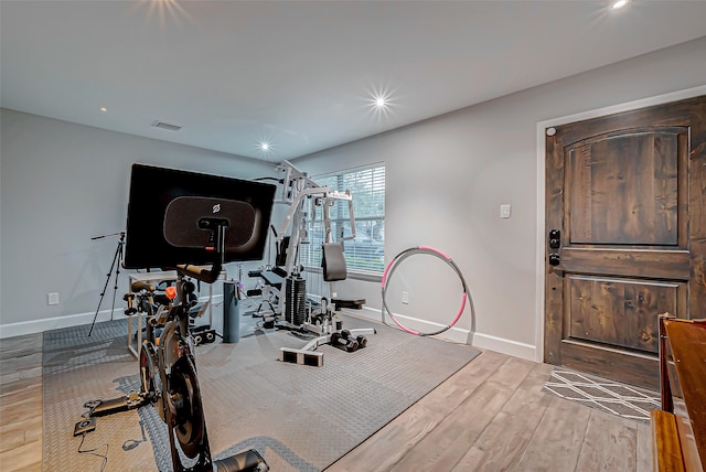 workout area with light hardwood / wood-style flooring