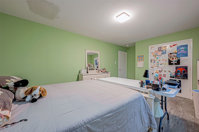 bedroom with hardwood / wood-style floors and a textured ceiling