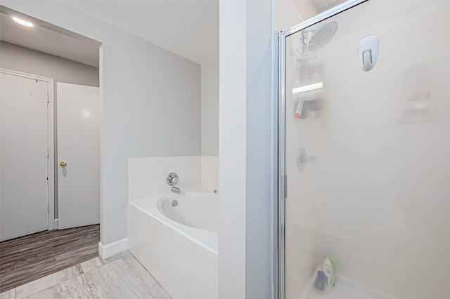 bathroom featuring plus walk in shower and wood-type flooring