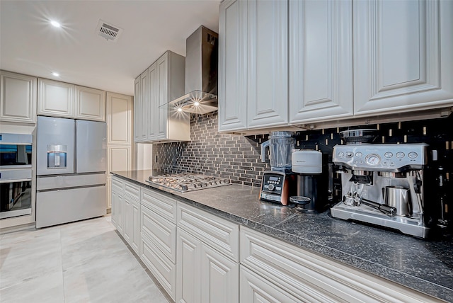 kitchen with backsplash, wall chimney exhaust hood, and stainless steel appliances