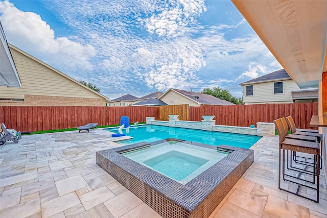 view of pool with an in ground hot tub and a patio area