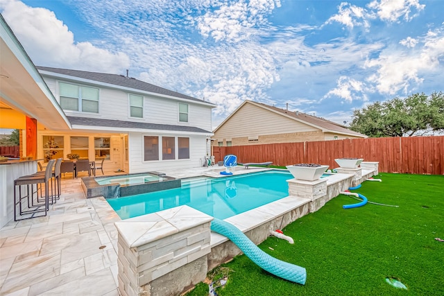 view of swimming pool with a patio, a bar, an in ground hot tub, and a yard