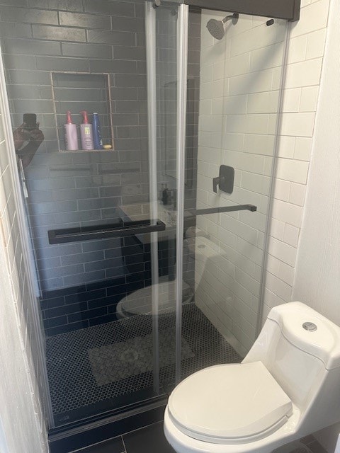 bathroom featuring an enclosed shower and toilet