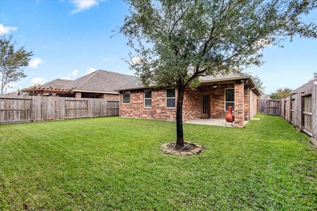 back of house with a patio and a lawn