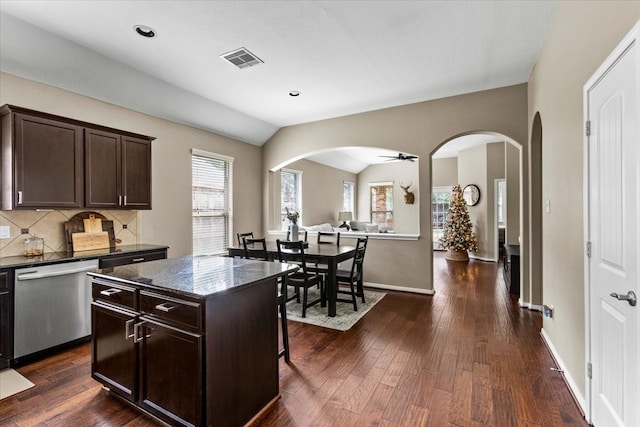 kitchen featuring dishwasher, a kitchen island, dark brown cabinetry, and lofted ceiling