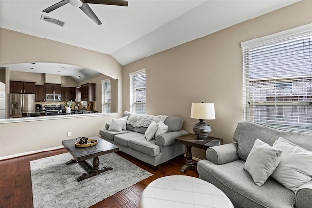 living room featuring dark hardwood / wood-style floors, vaulted ceiling, and ceiling fan