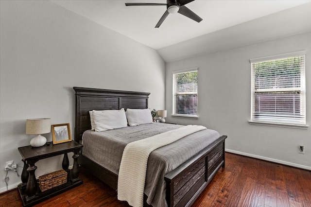 bedroom featuring multiple windows, dark hardwood / wood-style floors, vaulted ceiling, and ceiling fan