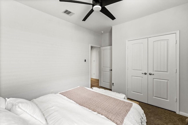 bedroom featuring ceiling fan, dark carpet, and a closet