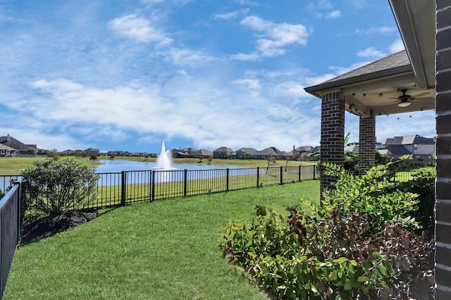 view of yard featuring ceiling fan and a water view