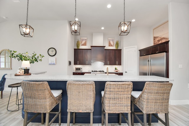 kitchen featuring a kitchen bar, light wood-type flooring, stainless steel appliances, and backsplash