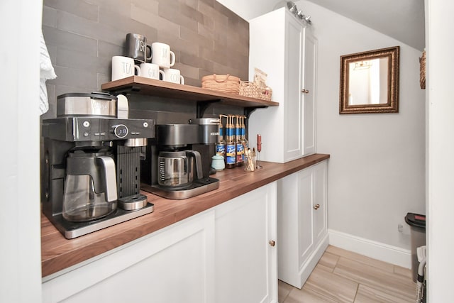 bar featuring white cabinets, wood counters, and backsplash