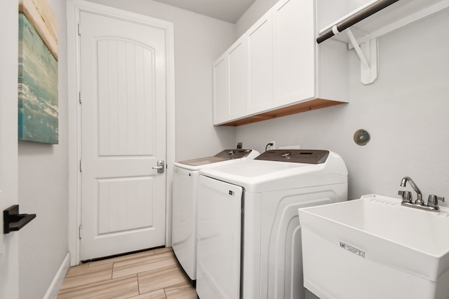 laundry area with separate washer and dryer, sink, cabinets, and light hardwood / wood-style flooring