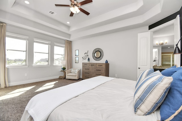 carpeted bedroom featuring a tray ceiling and ceiling fan