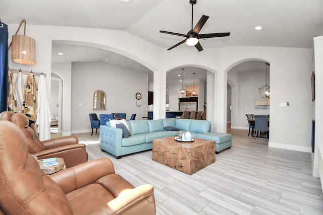 living room with light hardwood / wood-style floors, ceiling fan, and lofted ceiling