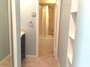 bathroom with tile patterned floors, vanity, and shower / bath combo with shower curtain