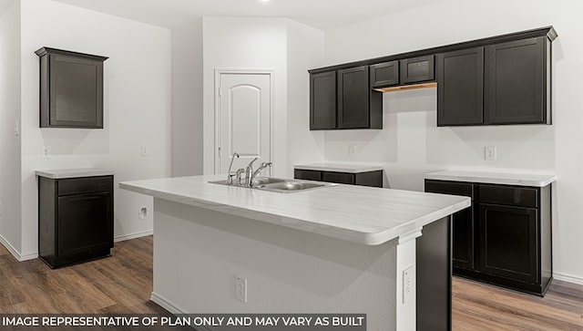 kitchen featuring dark hardwood / wood-style flooring, a center island with sink, and sink