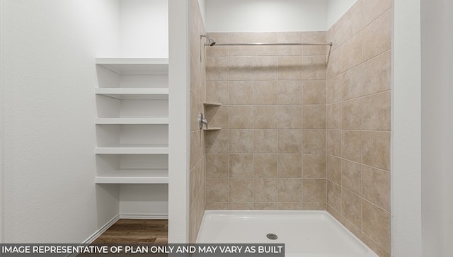 bathroom with hardwood / wood-style floors and tiled shower