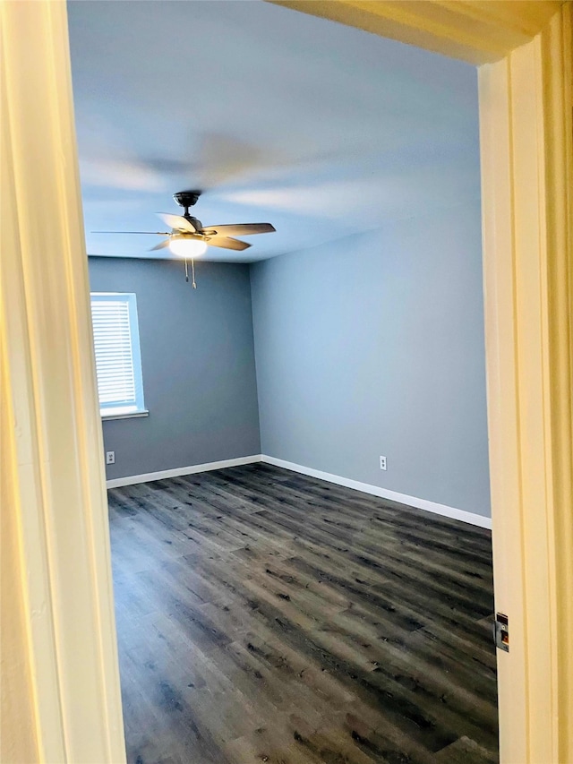 empty room featuring ceiling fan and dark wood-type flooring