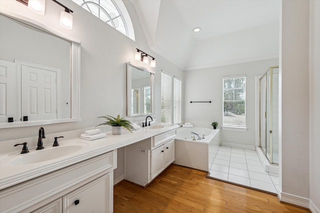 bathroom featuring vanity, plus walk in shower, wood-type flooring, and vaulted ceiling