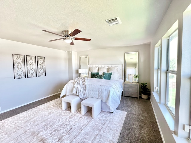 carpeted bedroom featuring multiple windows, ceiling fan, and a textured ceiling