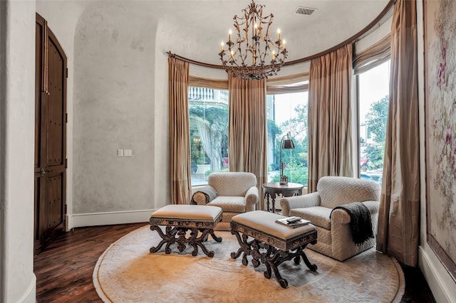 living area with dark wood-type flooring and an inviting chandelier