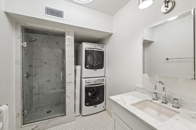 laundry area featuring stacked washer / drying machine and sink