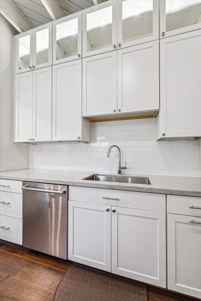 kitchen featuring dishwasher, sink, white cabinets, and backsplash