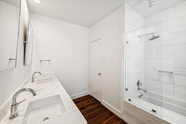 bathroom featuring hardwood / wood-style flooring, vanity, and tiled shower / bath combo